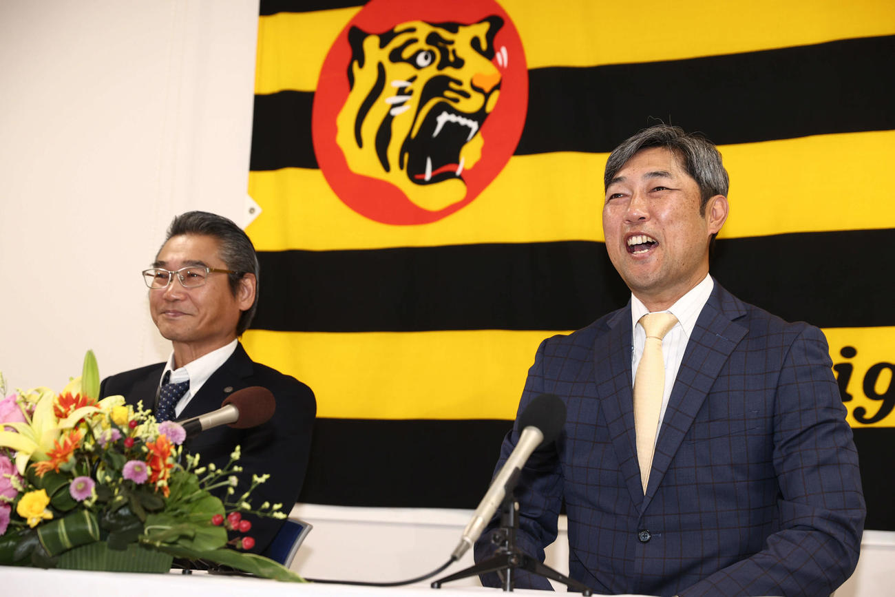 阪神1軍投手コーチに就任した金村氏は笑顔で抱負を述べる。左は嶌村球団本部長