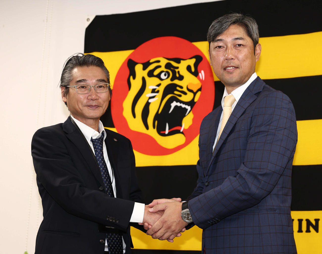 阪神1軍投手コーチに就任した金村暁氏（右）は嶌村聡球団本部長と握手を交わす