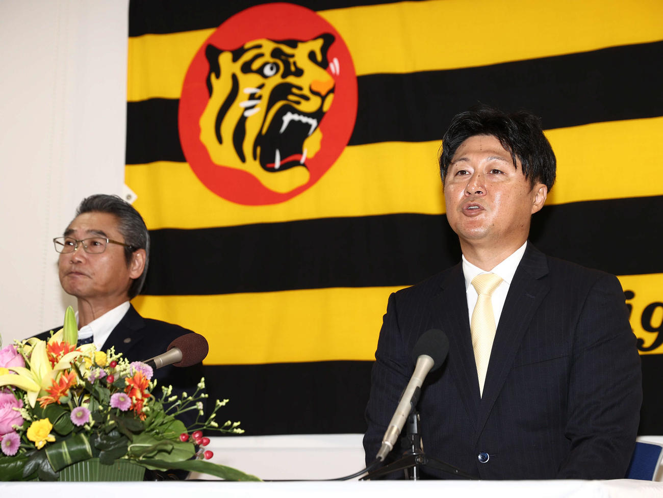 阪神2軍野手コーチに就任した俊介氏（藤川俊介）は抱負を語る。左は嶌村聡球団本部長