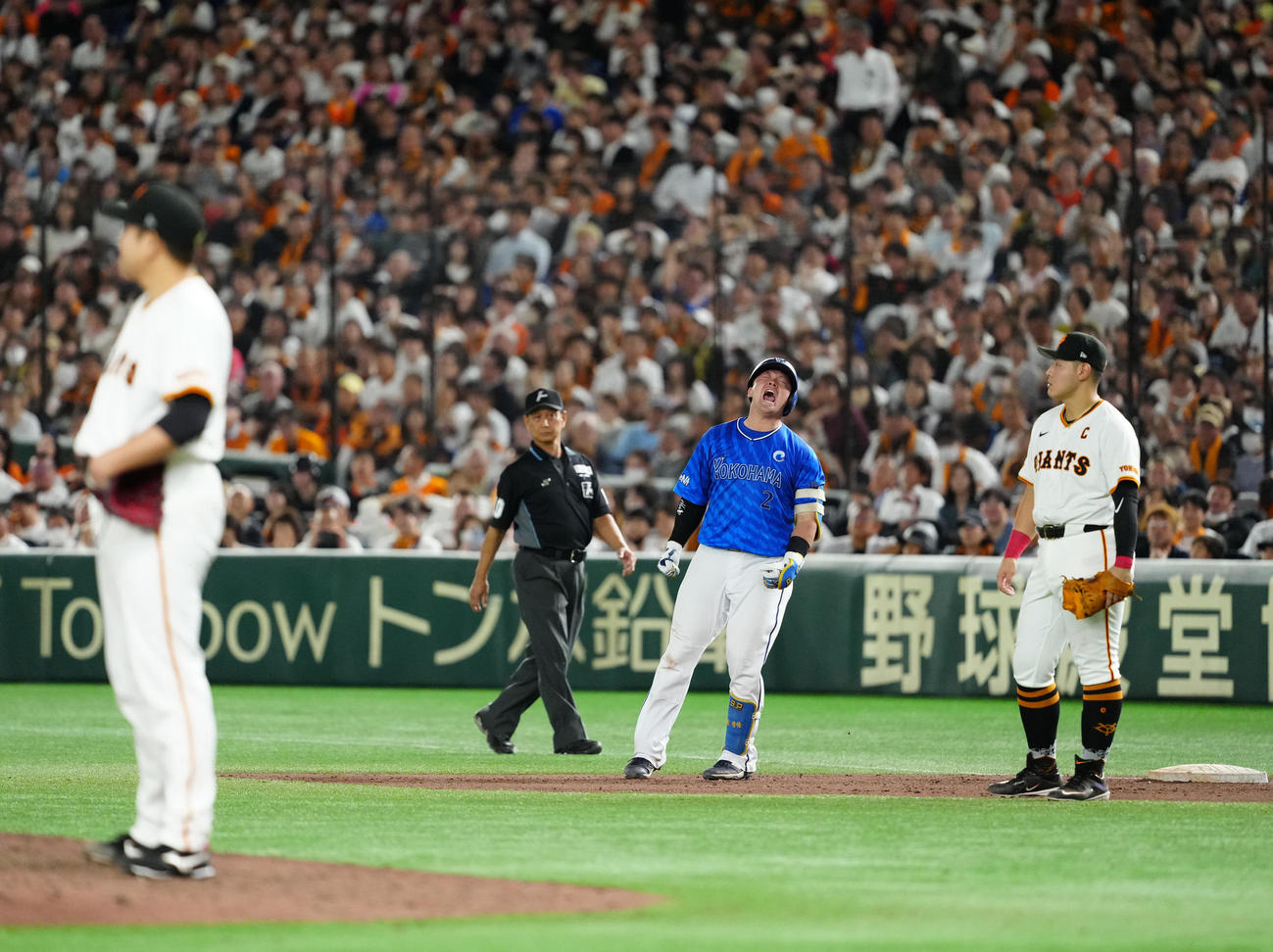 巨人対DeNA 9回表DeNA2死三塁、適時打を放ち雄たけびを上げる牧（中央）。右は一塁手岡本和、左は菅野（撮影・江口和貴）