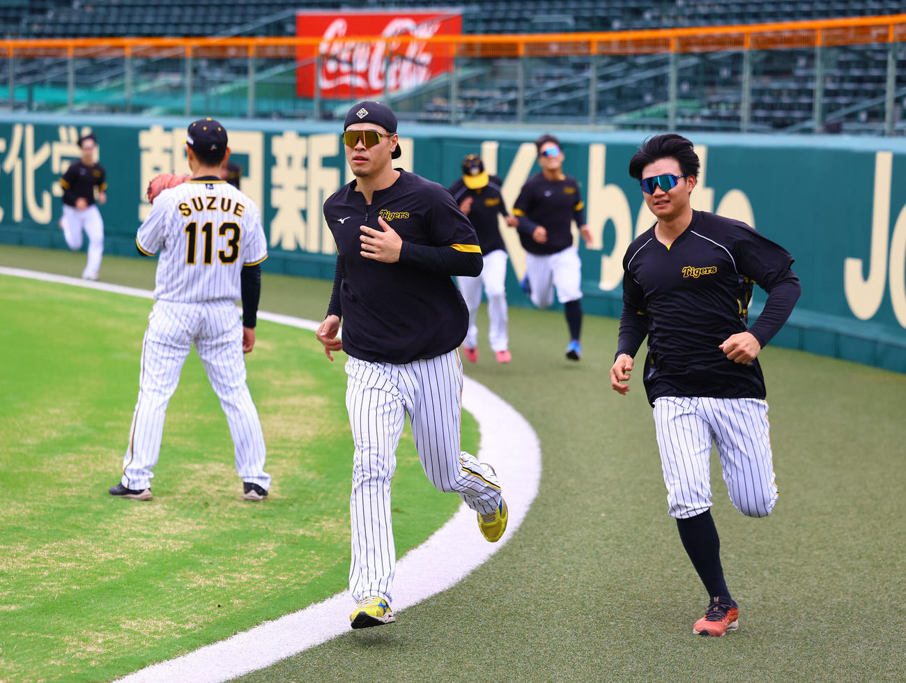 ランニングする阪神佐藤輝（左）と森下（撮影・藤尾明華）