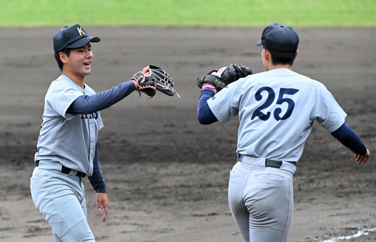 関大対関学大　8回に登板、関学大を3人で押さえた関大・金丸（左）は鹿熊と笑顔でグラブタッチ（撮影・前岡正明）