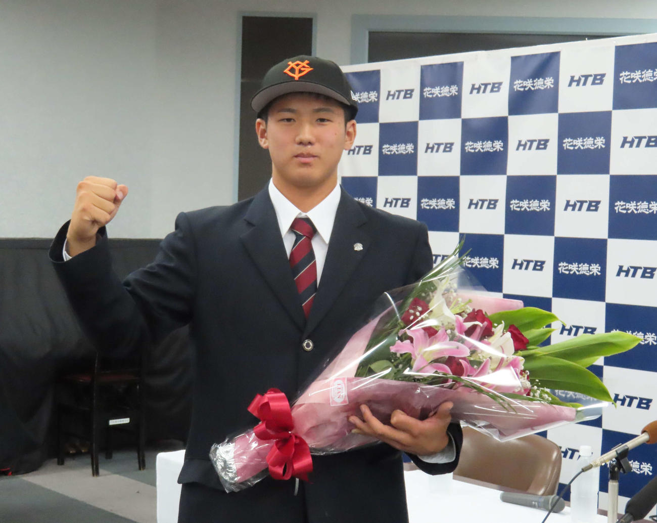 巨人からドラフト1位指名を受け、巨人の帽子をかぶり写真に納まる花咲徳栄・石塚（撮影・水谷京裕）