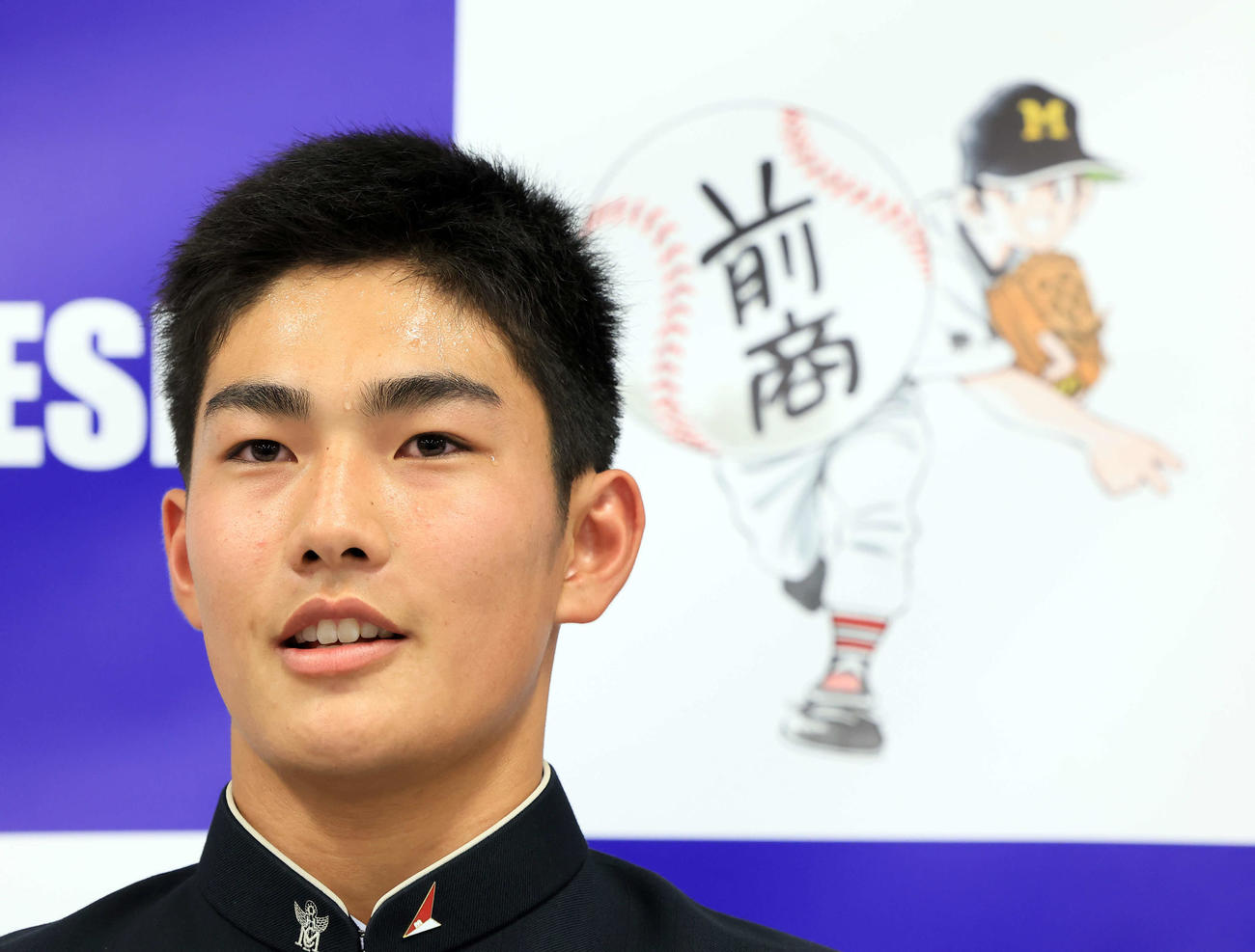 日本ハムドラフト4位で指名された前橋商・清水（中央）はあだち充氏の絵を背に汗だくになりながら会見に答える（撮影・浅見桂子）