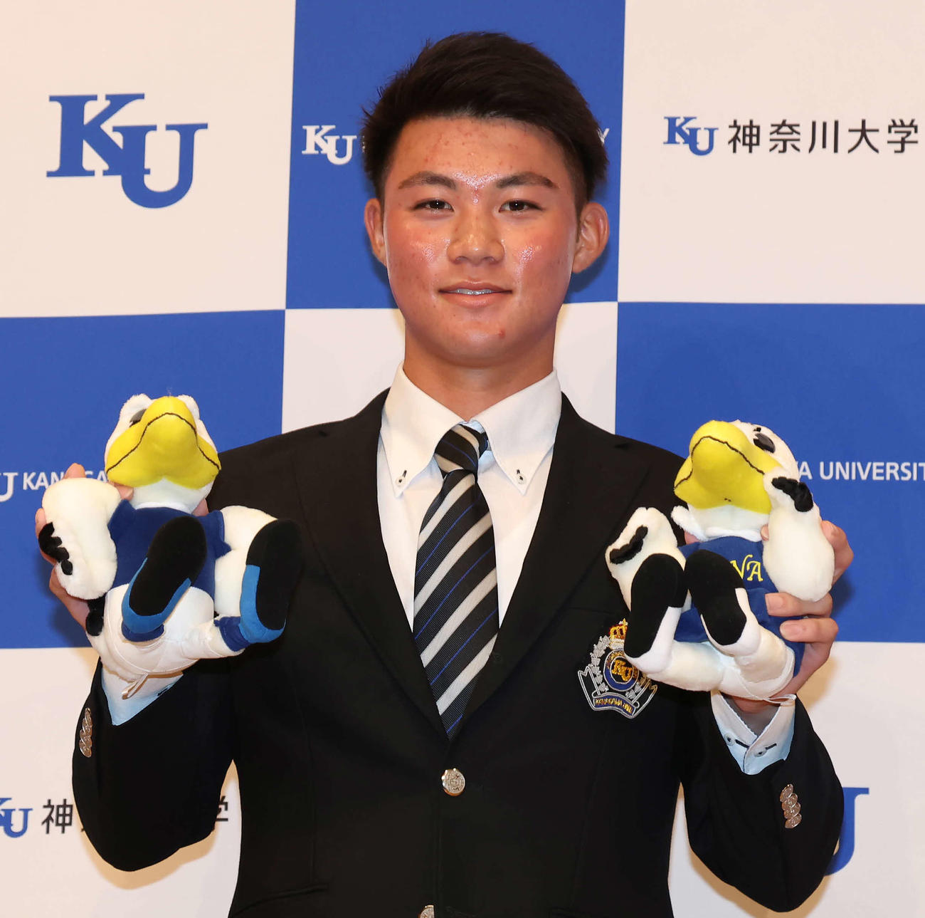 ソフトバンクの2位指名を受け、神奈川大のマスコット・ジンくんとカナちゃんを手に写真に納まる庄子（撮影・丹羽敏通）