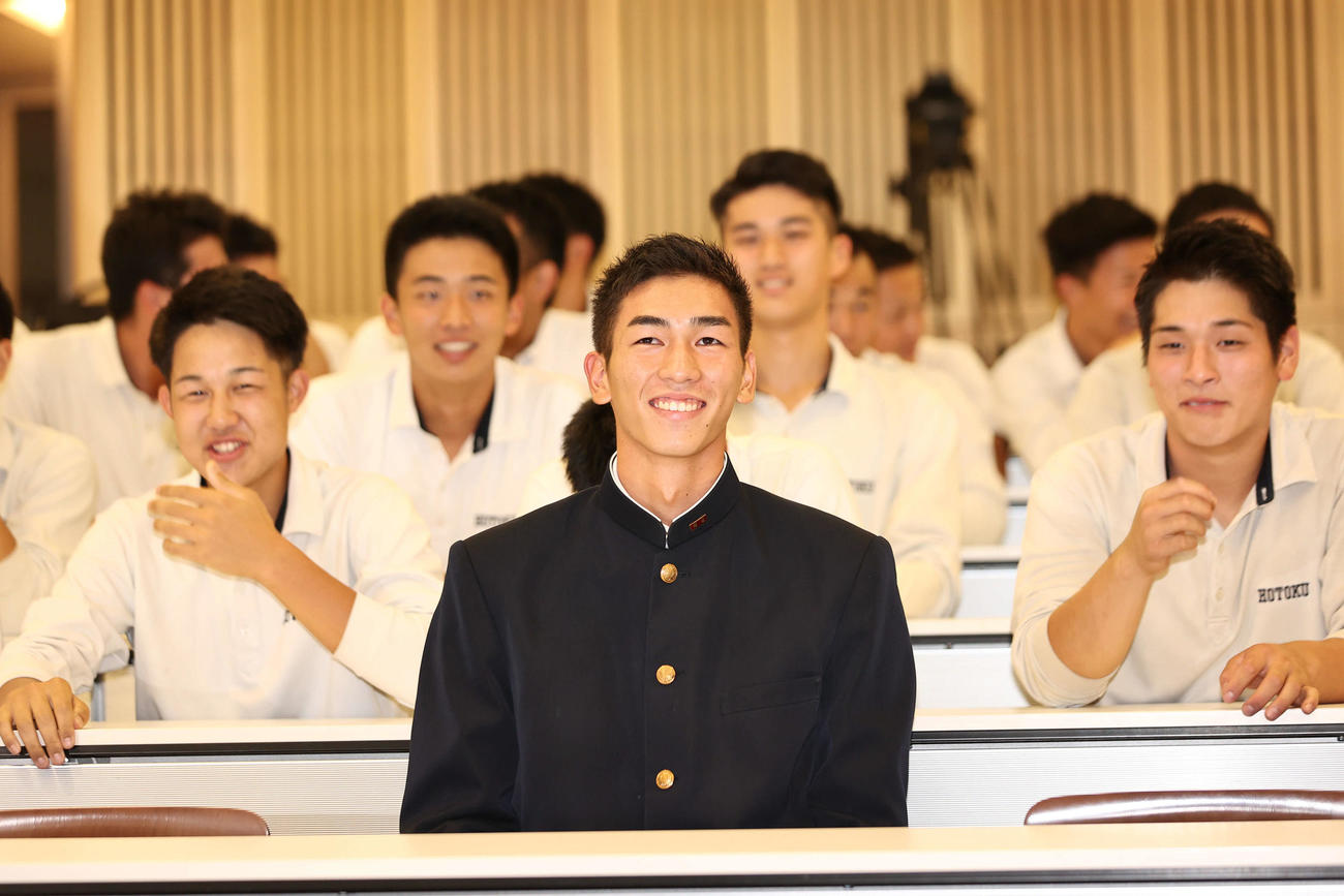報徳学園の今朝丸は穏やかな表情でチームメイトに囲まれながら指名を待つ（撮影・西尾就之）
