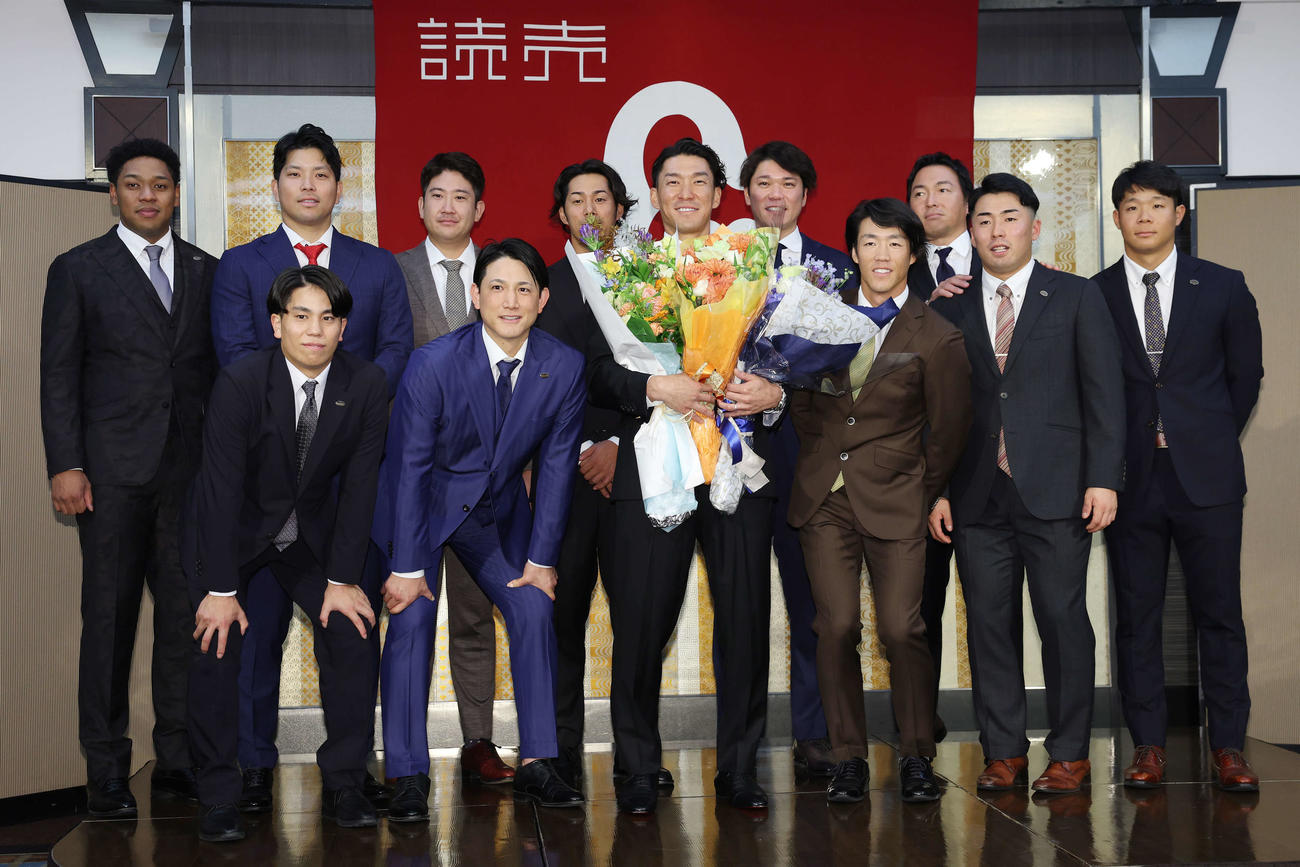 引退会見にサプライズで登場したチームメートたちと記念撮影する巨人梶谷（中央）、前列左から門脇、小林、1人おいて重信、浅野、佐々木、後列左からオコエ、大城卓、菅野、立岡、坂本、長野（撮影・宮地輝）