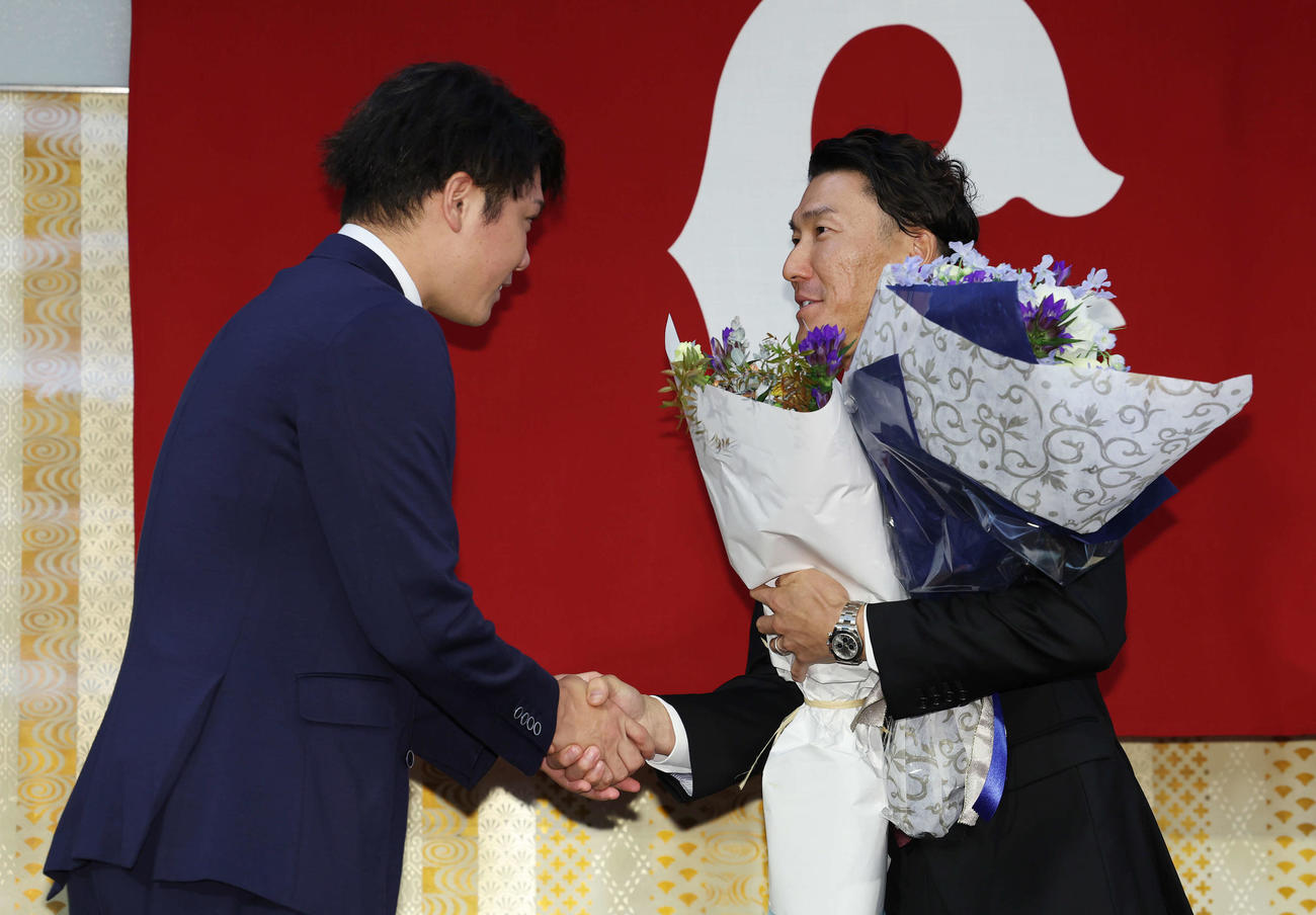 引退会見にサプライズで登場した巨人坂本（左）と握手する梶谷（撮影・宮地輝）