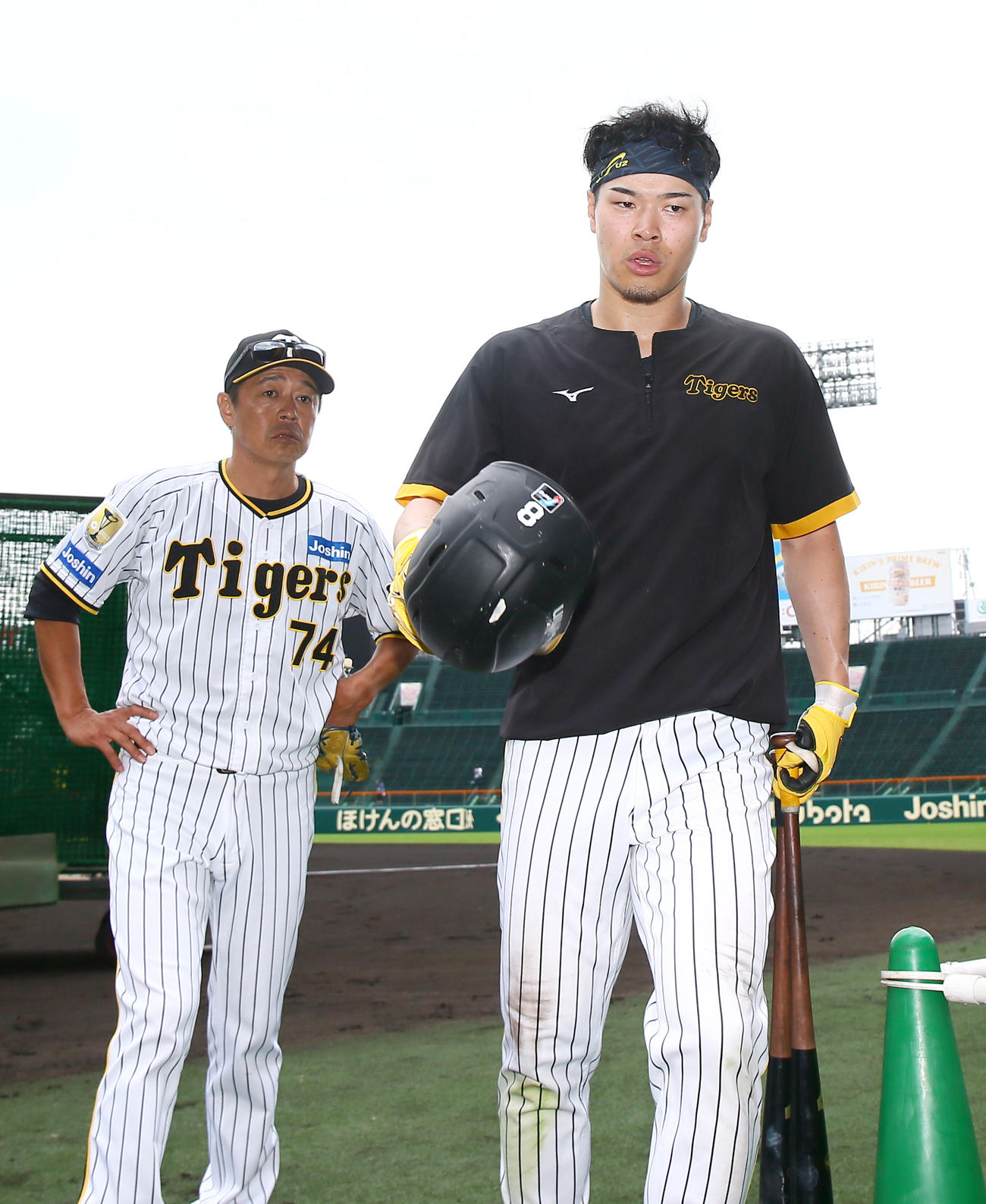 練習を終え引き揚げる阪神佐藤輝。奥は藤本総合コーチ（撮影・上山淳一）