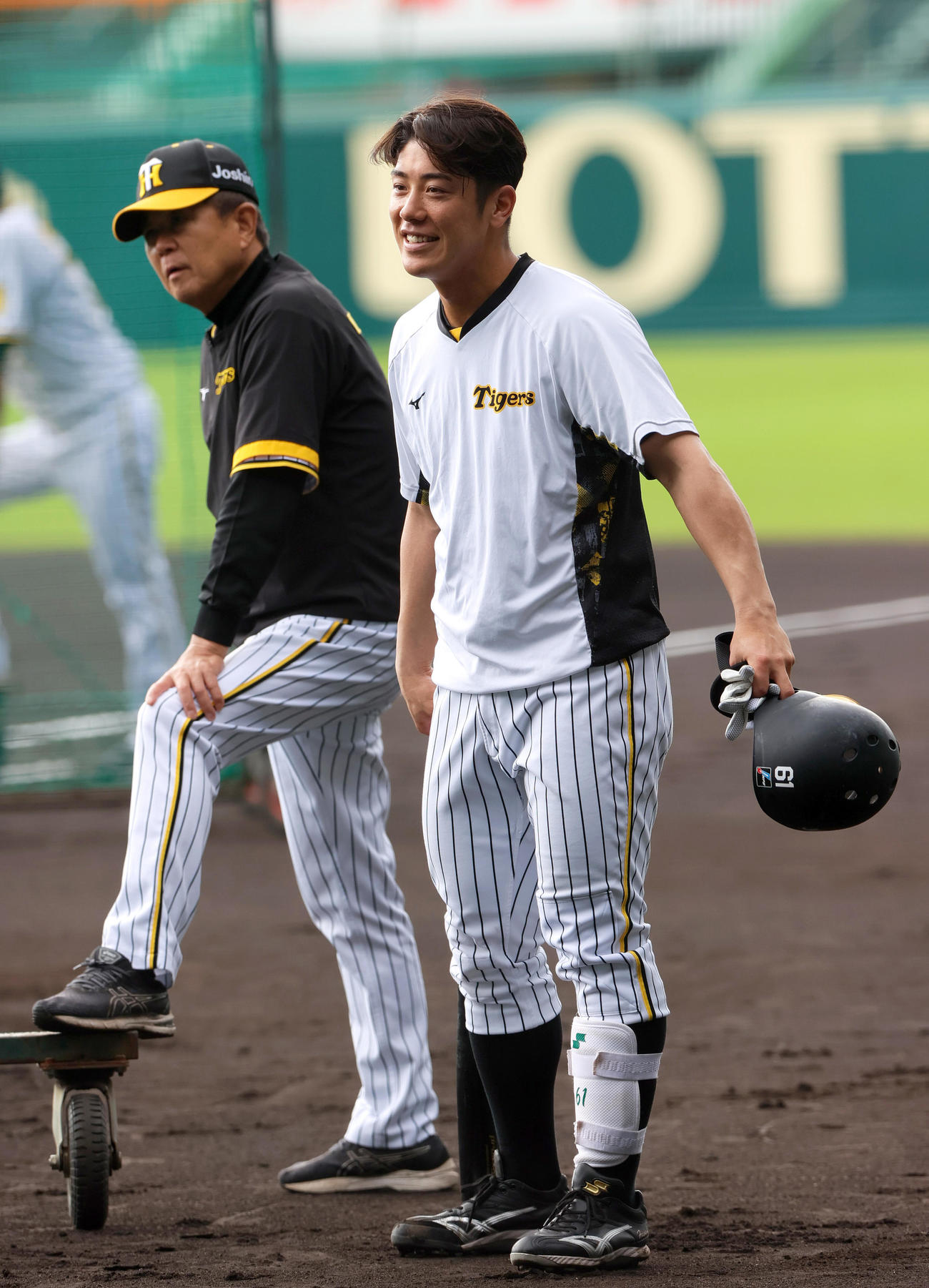 練習で笑顔を見せる阪神豊田。左は阪神平田2軍監督（撮影・上山淳一）