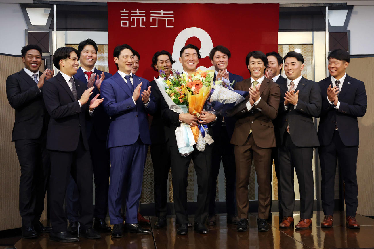 引退会見で巨人梶谷（中央）を拍手で送るチームメートたち、前列左から門脇、小林、1人おいて重信、浅野、佐々木、後列左からオコエ、大城卓、菅野、立岡、坂本、長野（撮影・宮地輝）
