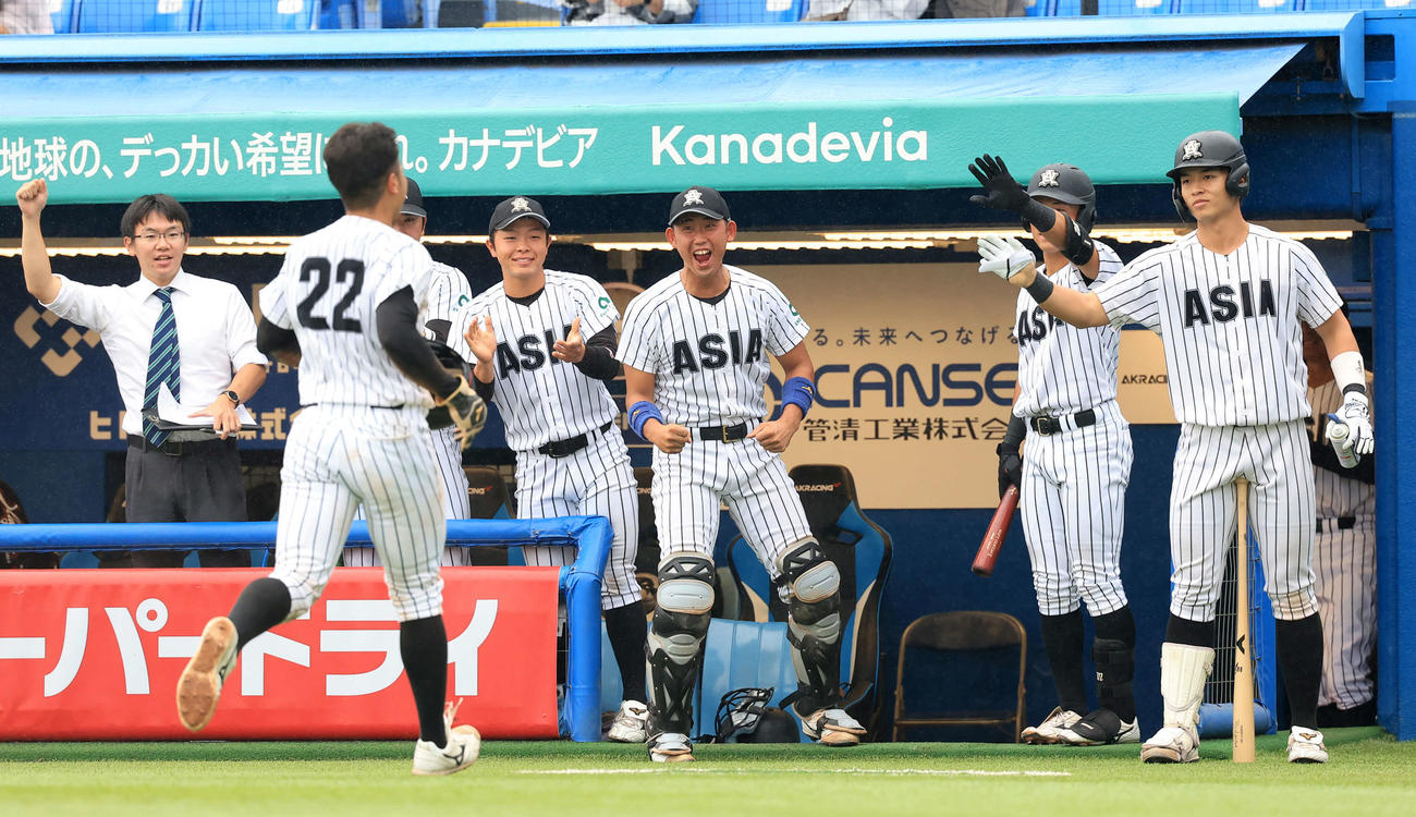 日大対亜大　3回裏亜大1死二、三塁、的場の打撃で生還した前嶋を迎える亜大ナイン（撮影・浅見桂子）
