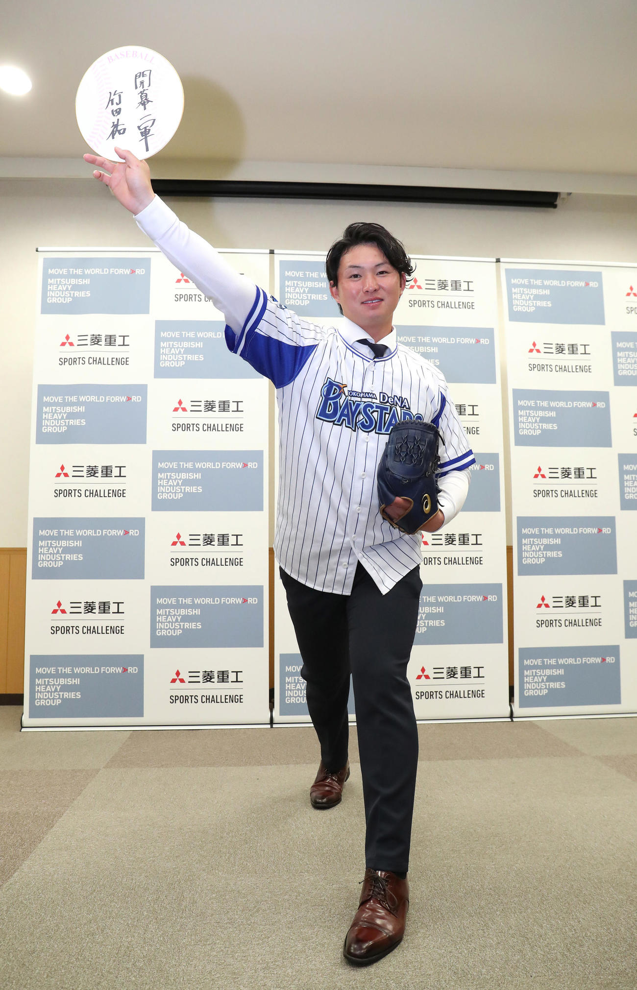 開幕一軍のと書いた色紙を投球フォームで掲げるDeNAからドラフト1位指名を受けた三菱重工Westの竹田（撮影・白石智彦）