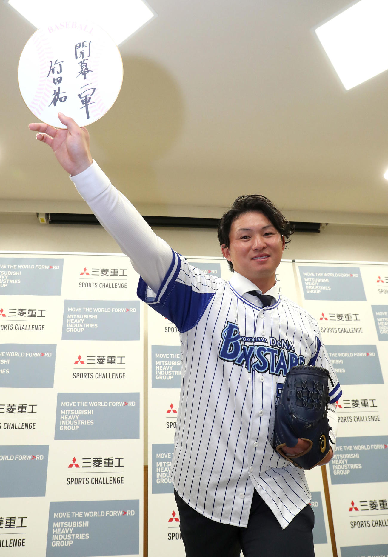 開幕一軍のと書いた色紙を投球フォームで掲げるDeNAからドラフト1位指名を受けた三菱重工Westの竹田（撮影・白石智彦）