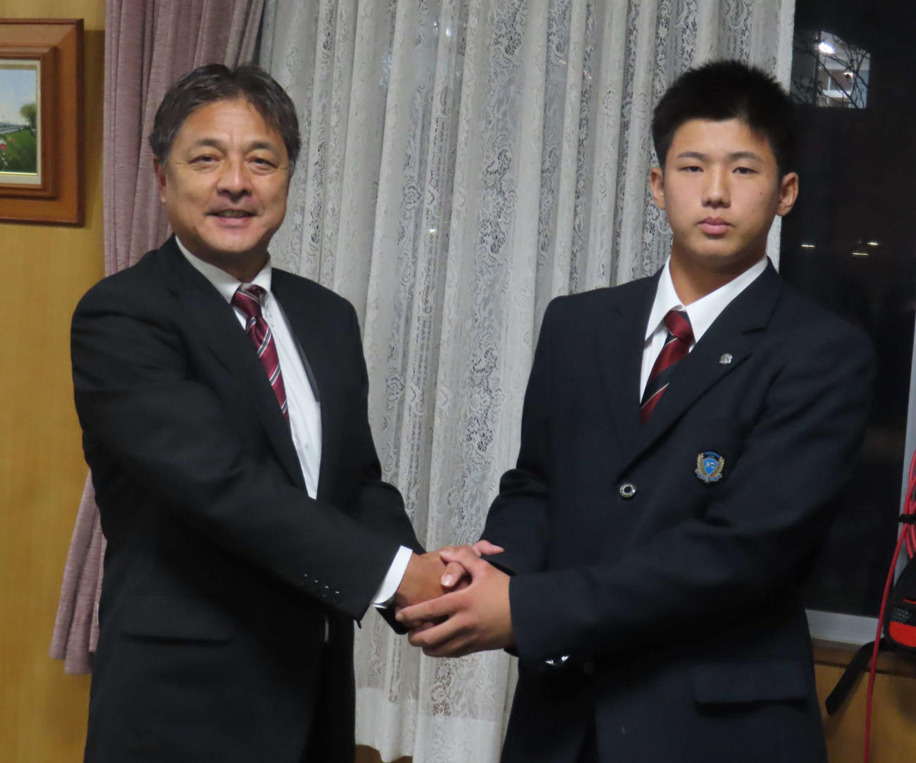 巨人からドラフト1位指名を受け、花咲徳栄・関校長（左）と握手する石塚（撮影・水谷京裕）