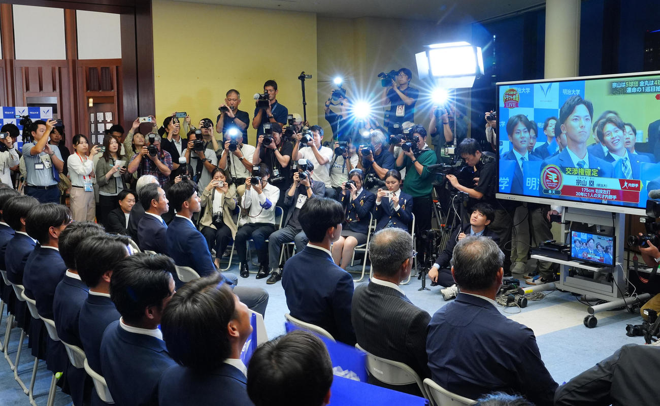 ドラフト1位指名での5球団入札で楽天が交渉権を獲得し、画面を見つめる明大・宗山ら（撮影・江口和貴）