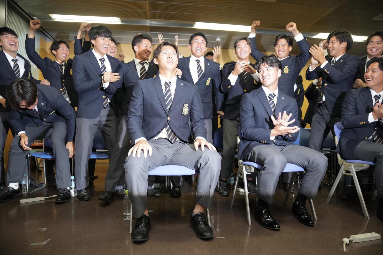 日本ハムから指名を受けほっとした表情を見せる法大・山城（手前左）。右は篠木（撮影・垰建太）