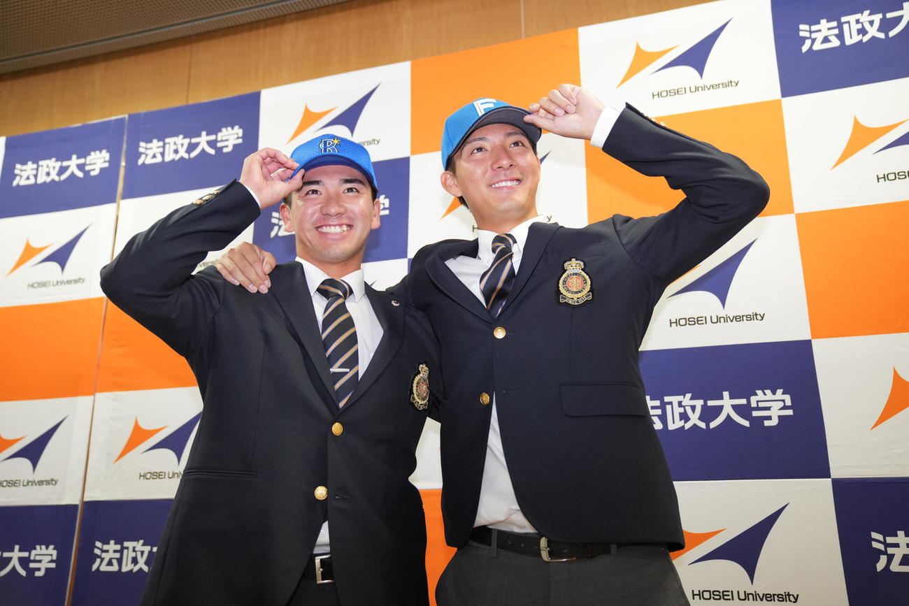指名を受け笑顔で写真に納まる法大・日本ハム6位山城（右）とDeNA2位篠木（撮影・垰建太）