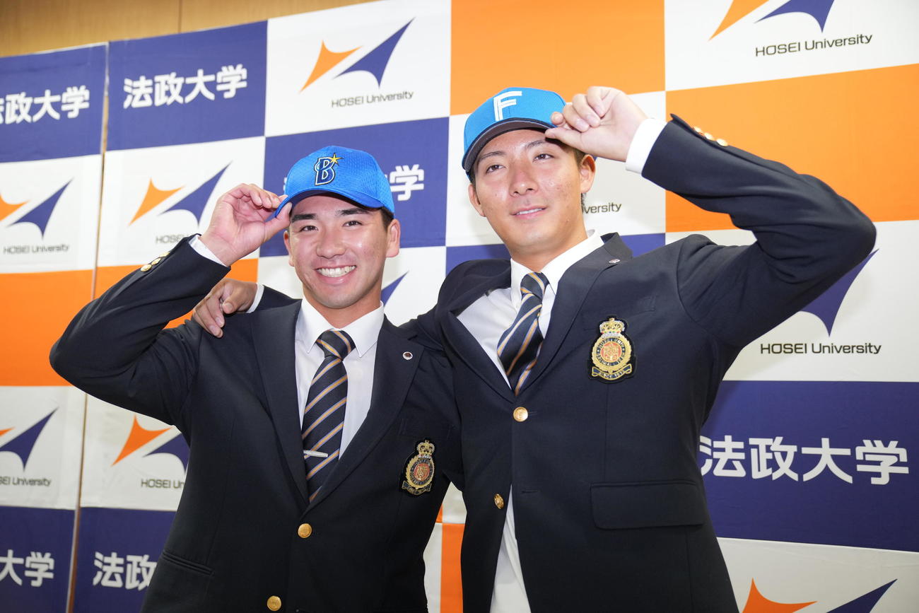 指名を受け笑顔で写真に納まる法大・日本ハム6位山城（右）とDeNA2位篠木（撮影・垰建太）