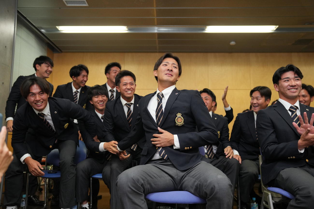 日本ハムから指名を受けほっとした表情を見せる法大・山城（手前左）。右は篠木（撮影・垰建太）