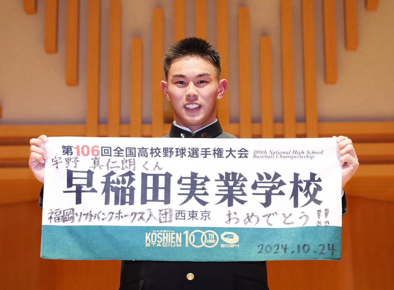 ソフトバンクから4位指名された早実・宇野は甲子園の記念タオルを手に笑顔を見せる（撮影・足立雅史）