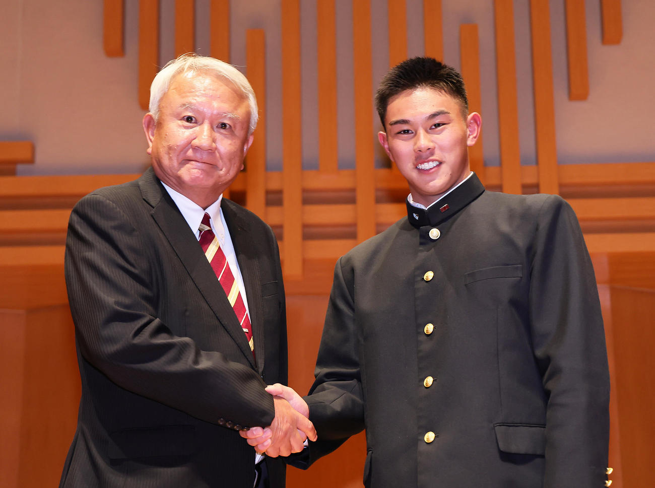 ソフトバンクから4位指名された早実・宇野（右）は和泉監督と握手を交わす（撮影・足立雅史）