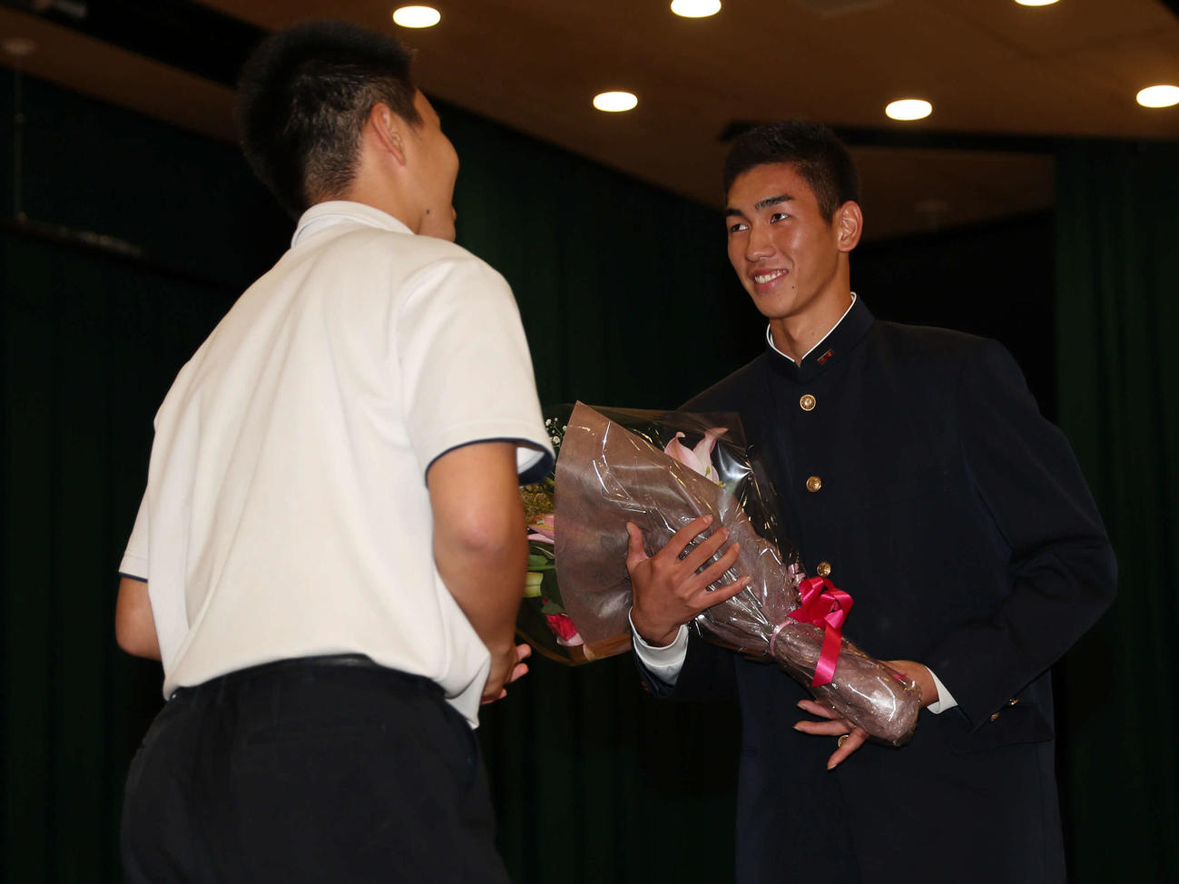 阪神2位指名の報徳学園・今朝丸（右）はチームメイトから祝福の花束を受け取る（撮影・西尾就之）