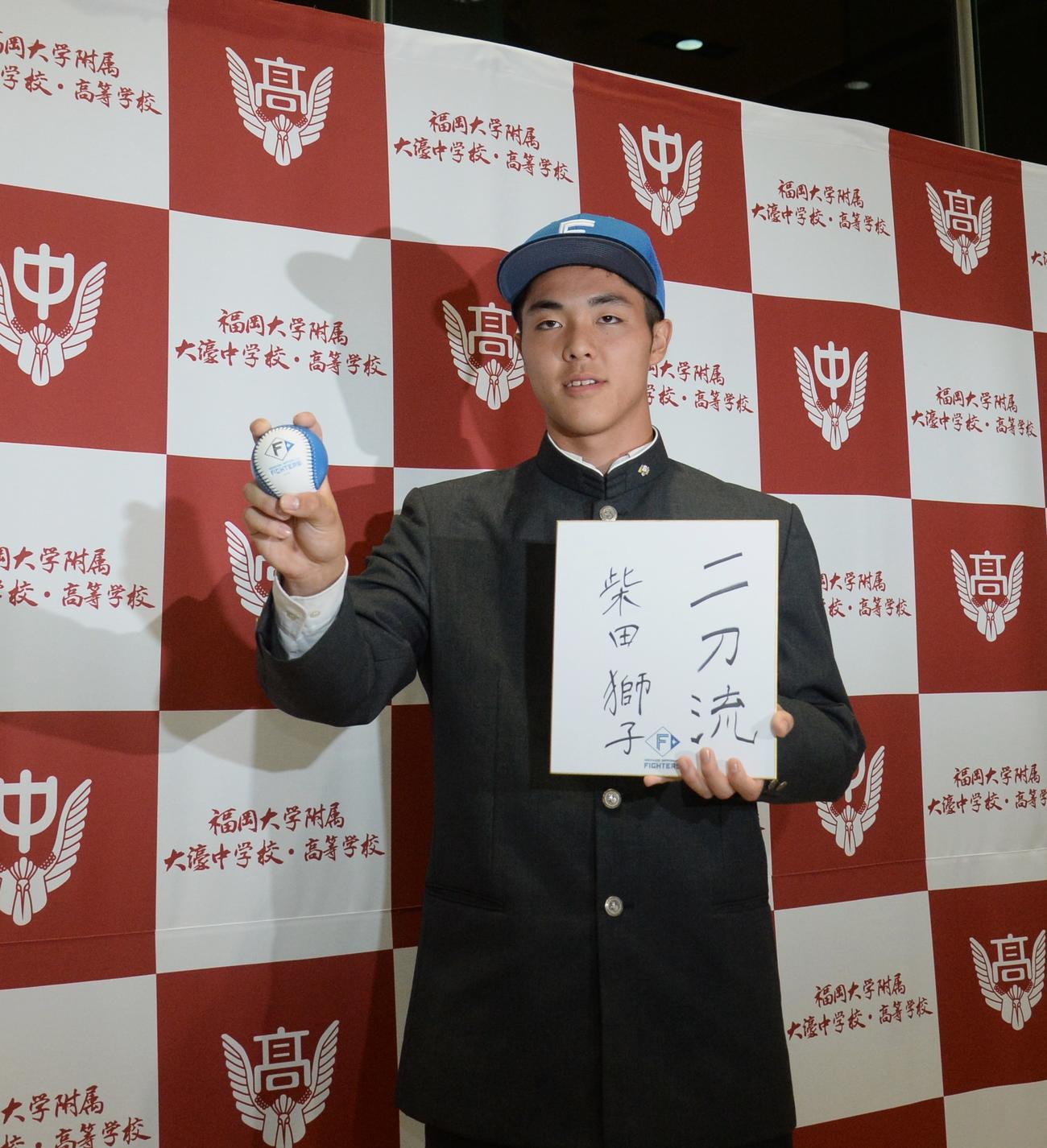 日本ハムから1位指名された福岡大大濠・柴田は色紙を手に笑顔（撮影・佐藤究）
