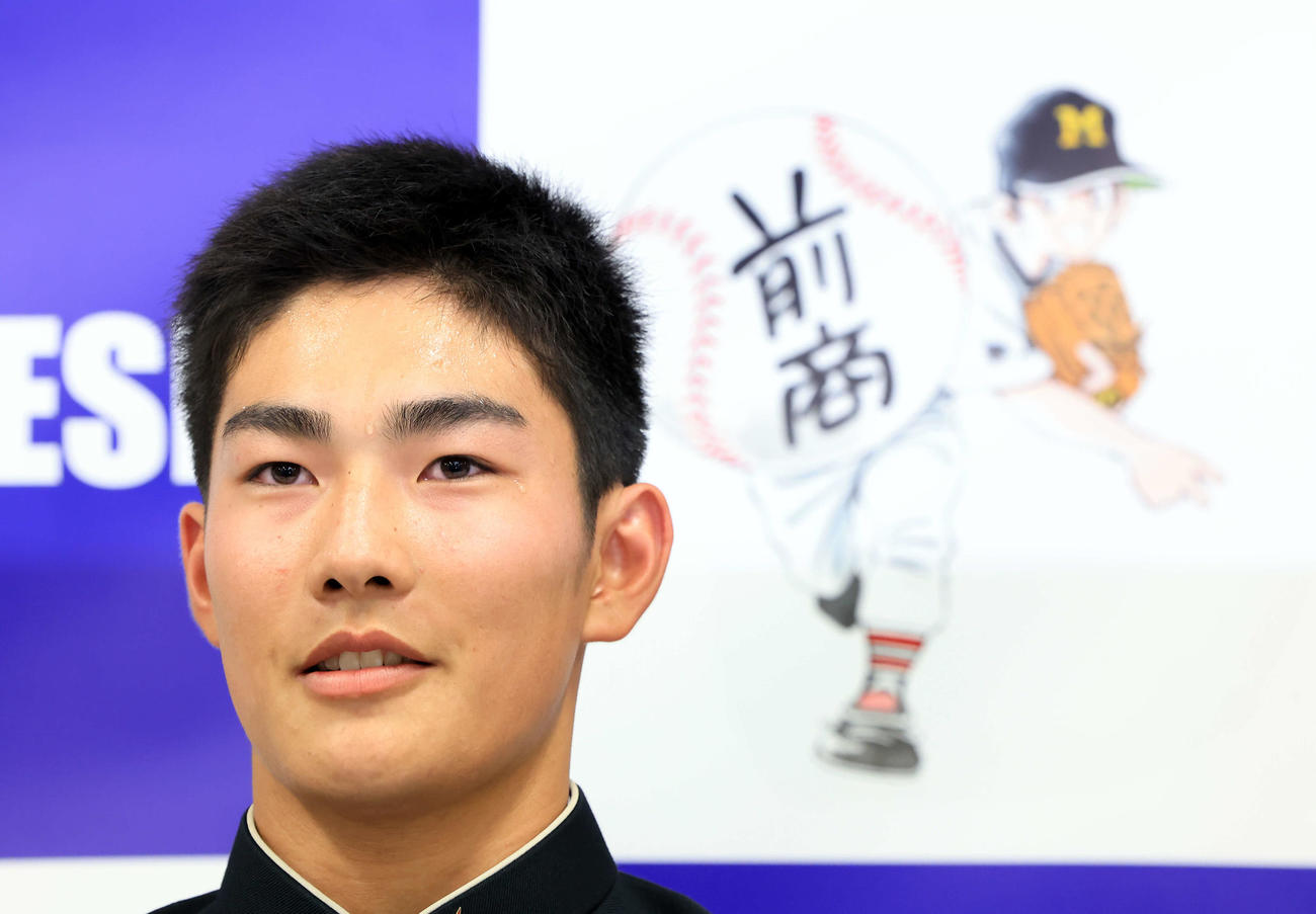 日本ハムドラフト4位で指名された前橋商・清水（中央）はあだち充氏の絵を背に汗だくになりながら会見に答える（撮影・浅見桂子）
