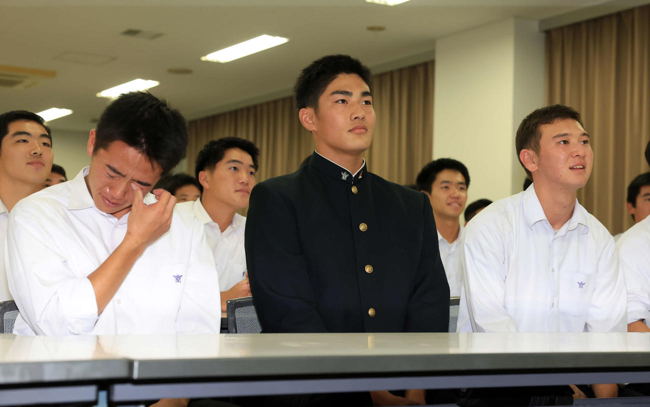 日本ハムドラフト4位で指名された前橋商・清水（中央）は野球部員が涙を流す中、ほっとした表情を見せる（撮影・浅見桂子）