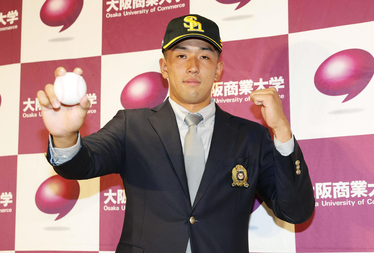 ソフトバンクから育成9位で指名を受け、ボールを手にガッツポーズする大商大・岡田（撮影・前田充）