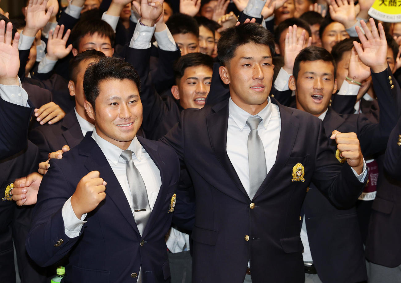 肩を組みガッツポーズする、西武から2位指名を受けた大商大・渡部（手前左）とソフトバンクから育成9位で指名を受けた岡田（同右）（撮影・前田充）