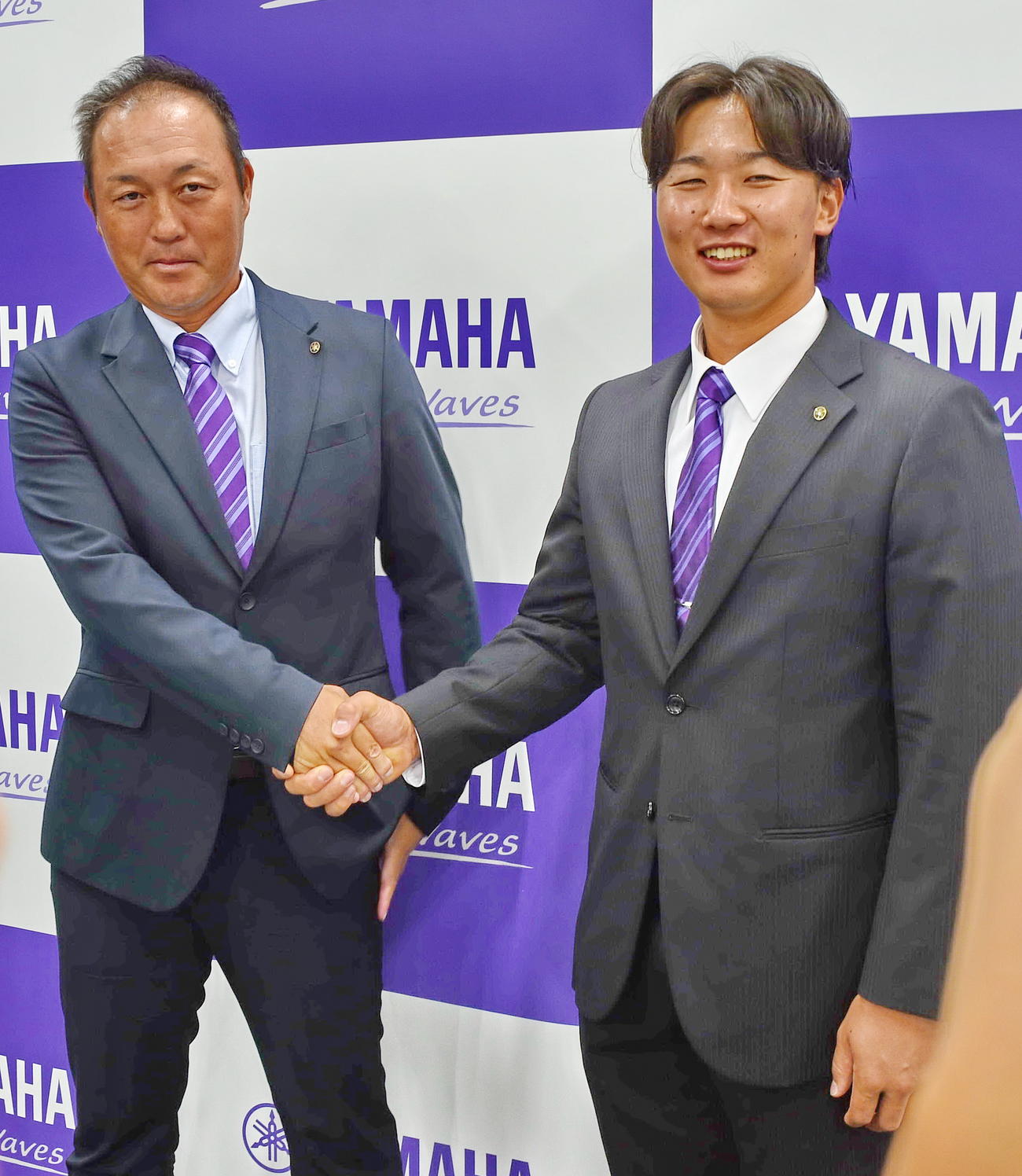会見終了後、ヤマハ申原監督（左）と握手をかわす宮崎　　　　　　　　　