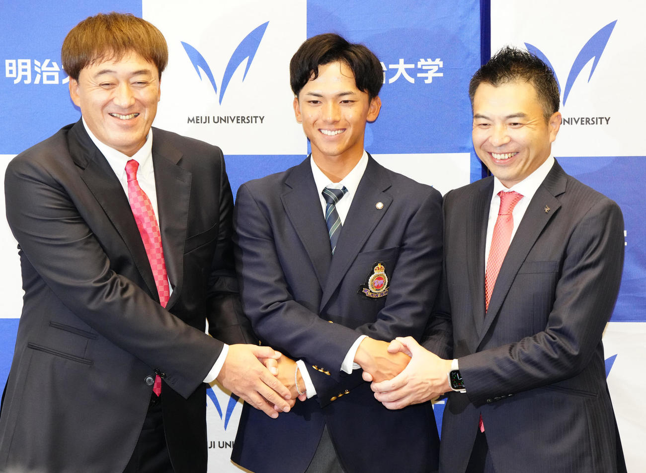 指名あいさつを受け、楽天森井球団社長（右）、石井取締役シニアディレクター（左）と握手を交わす明大・宗山（撮影・江口和貴）