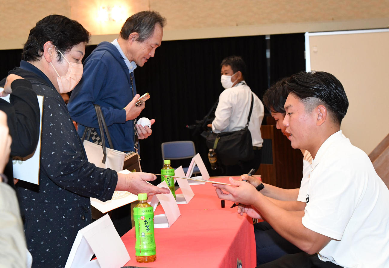 阪神から育成2巡目で指名された嶋村はファンにサイン。奥はDeNAにドラフト4巡目で指名された若松（撮影・前岡正明）