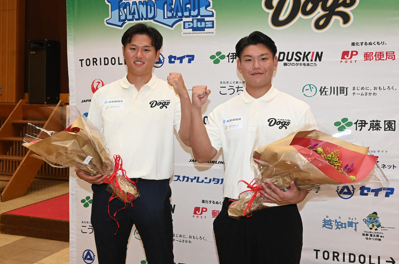DeNAにドラフト4巡目で指名された高知ファイテングドックス若松尚輝（左）と阪神から育成2巡目で指名された嶋村麟士朗は花束を手に笑顔を見せる（撮影・前岡正明）