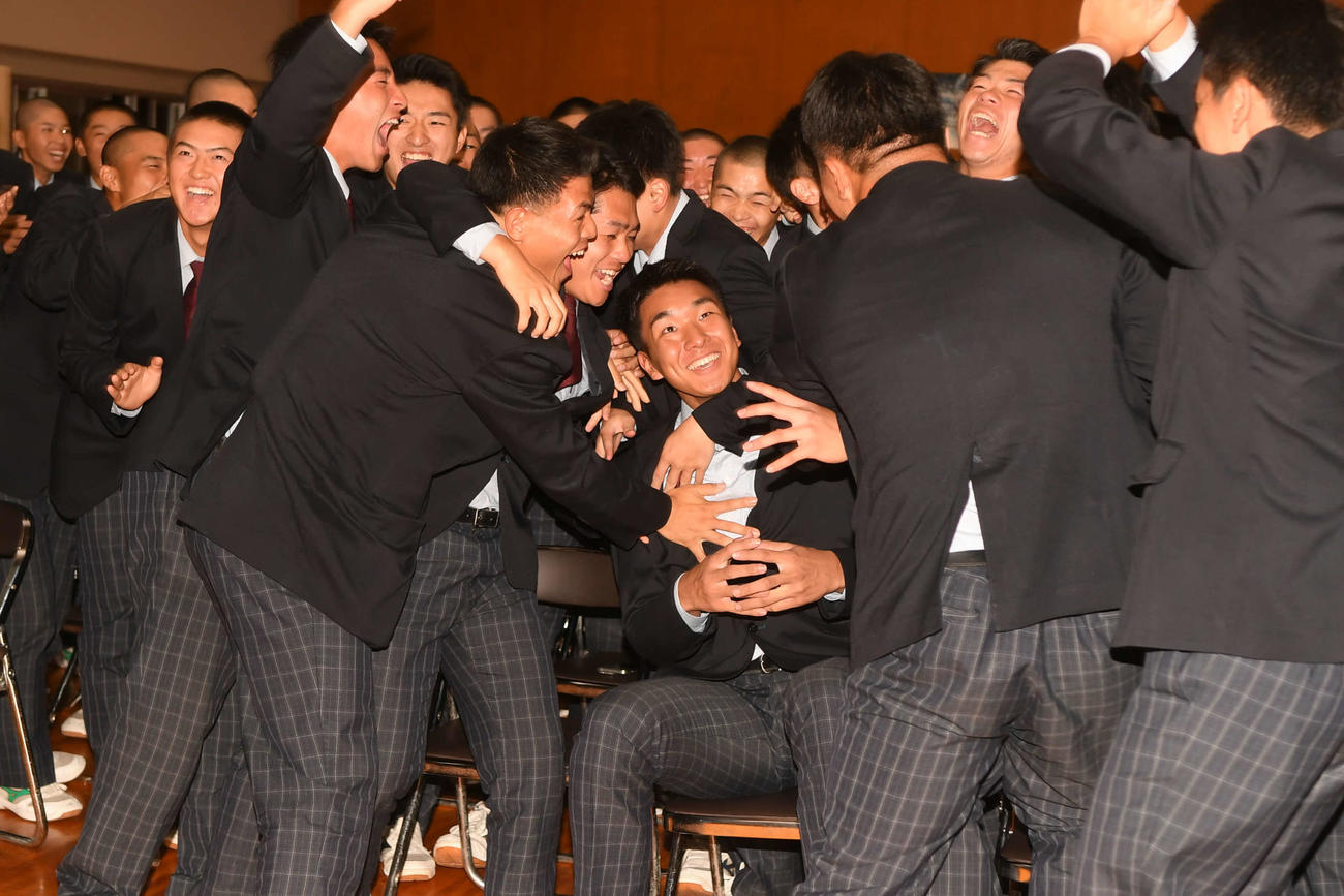 指名直後、チームメートの祝福を受けてもみくちゃにされる茨木（中央）