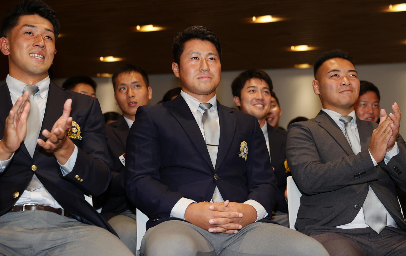 西武から2位指名を受け、笑顔を見せる大商大・渡部（中央）（撮影・前田充）