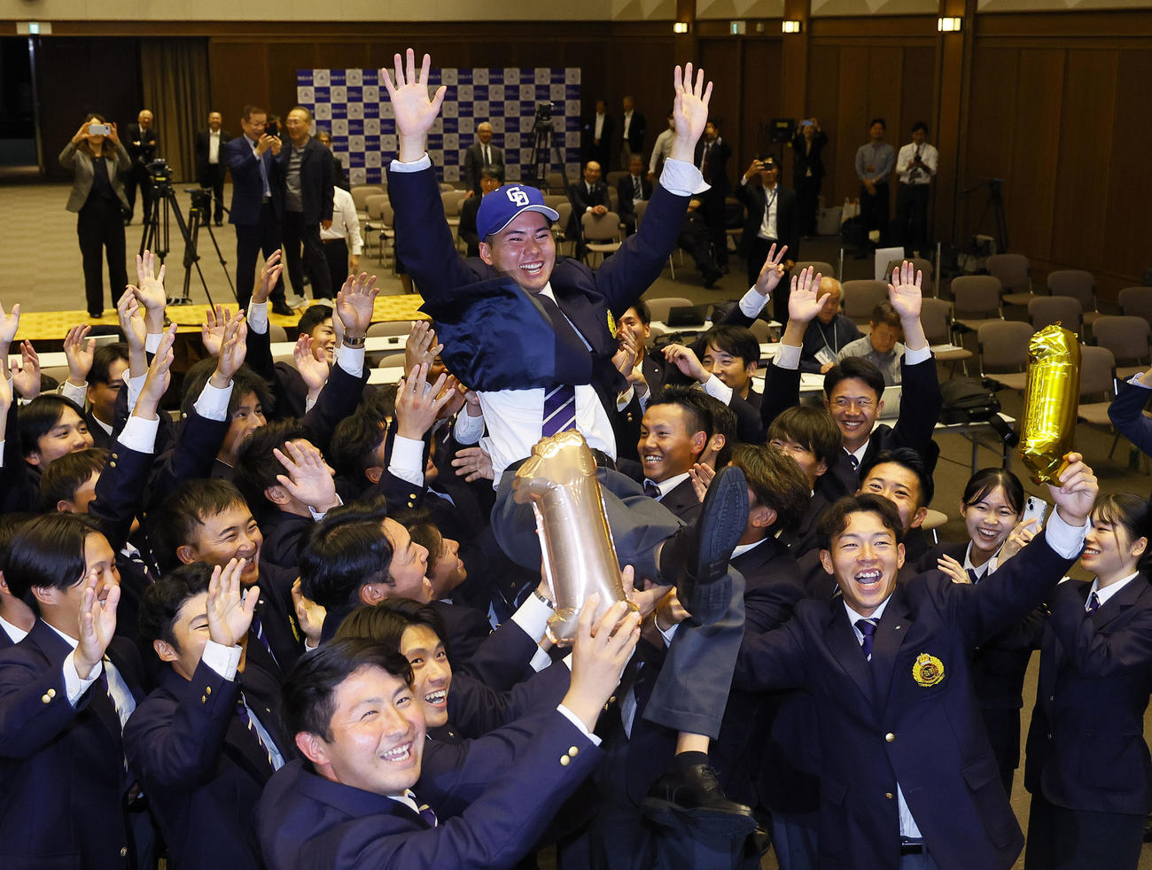 中日から1位指名を受け、仲間から胴上げされる関大・金丸（撮影・藤尾明華）