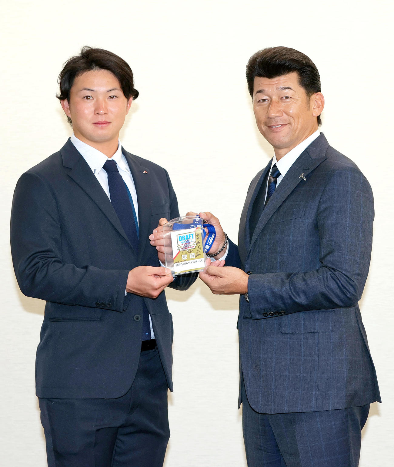 三菱重工West竹田（左）はDeNA三浦監督からドラフト会議入館パスを受け取り写真に納まる（撮影・上山淳一）