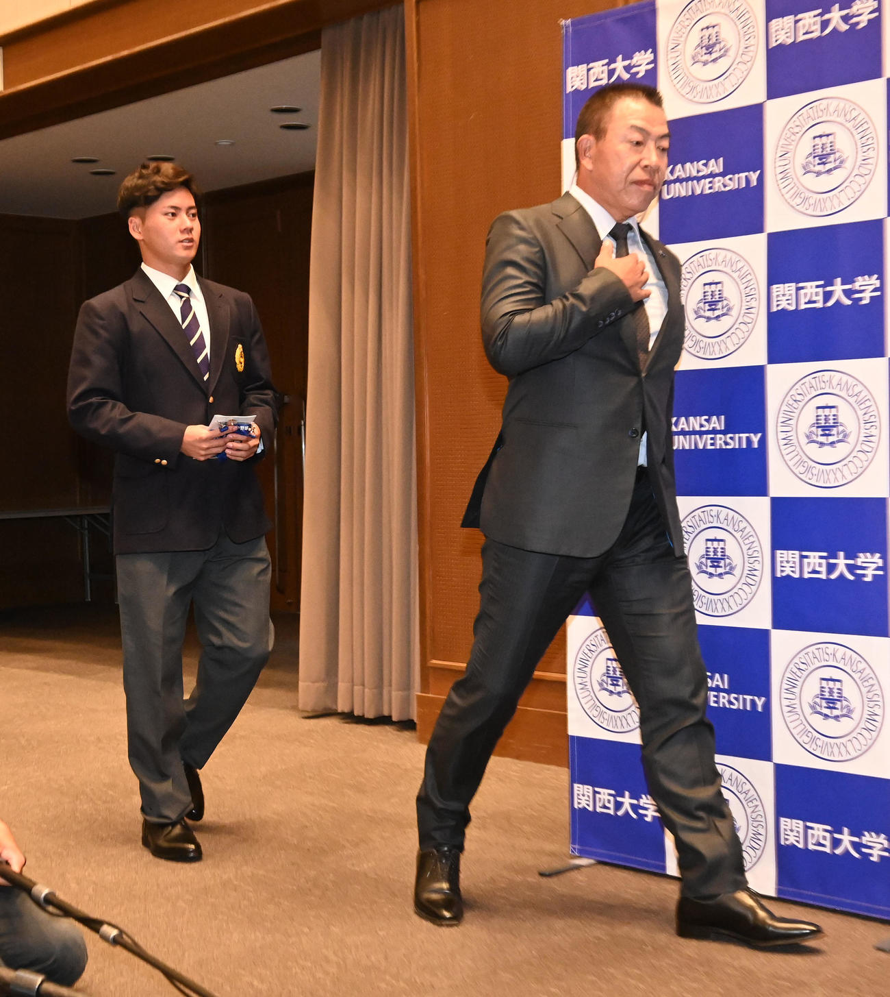 指名あいさつを終え囲み取材に向かう中日井上監督（右）と関大・金丸（撮影・前岡正明）