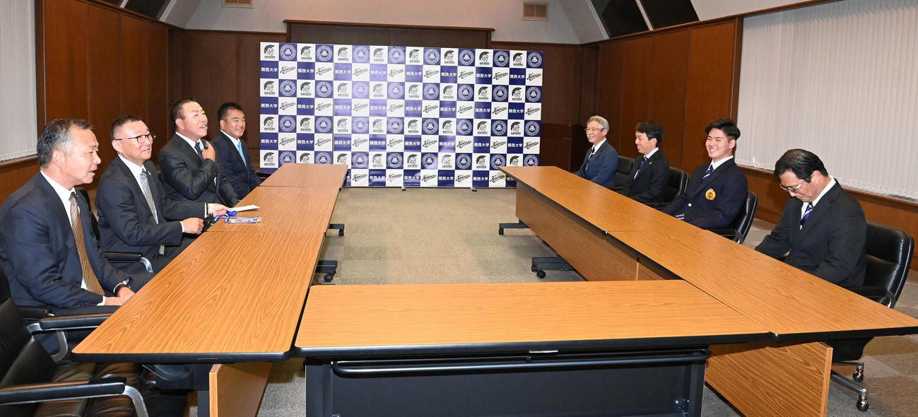 指名あいさつに訪れた井上監督（左列左から3人目）ら中日関係者と笑顔で話す金丸（右列右から42人目）ら関西大学関係者（撮影・前岡正明）
