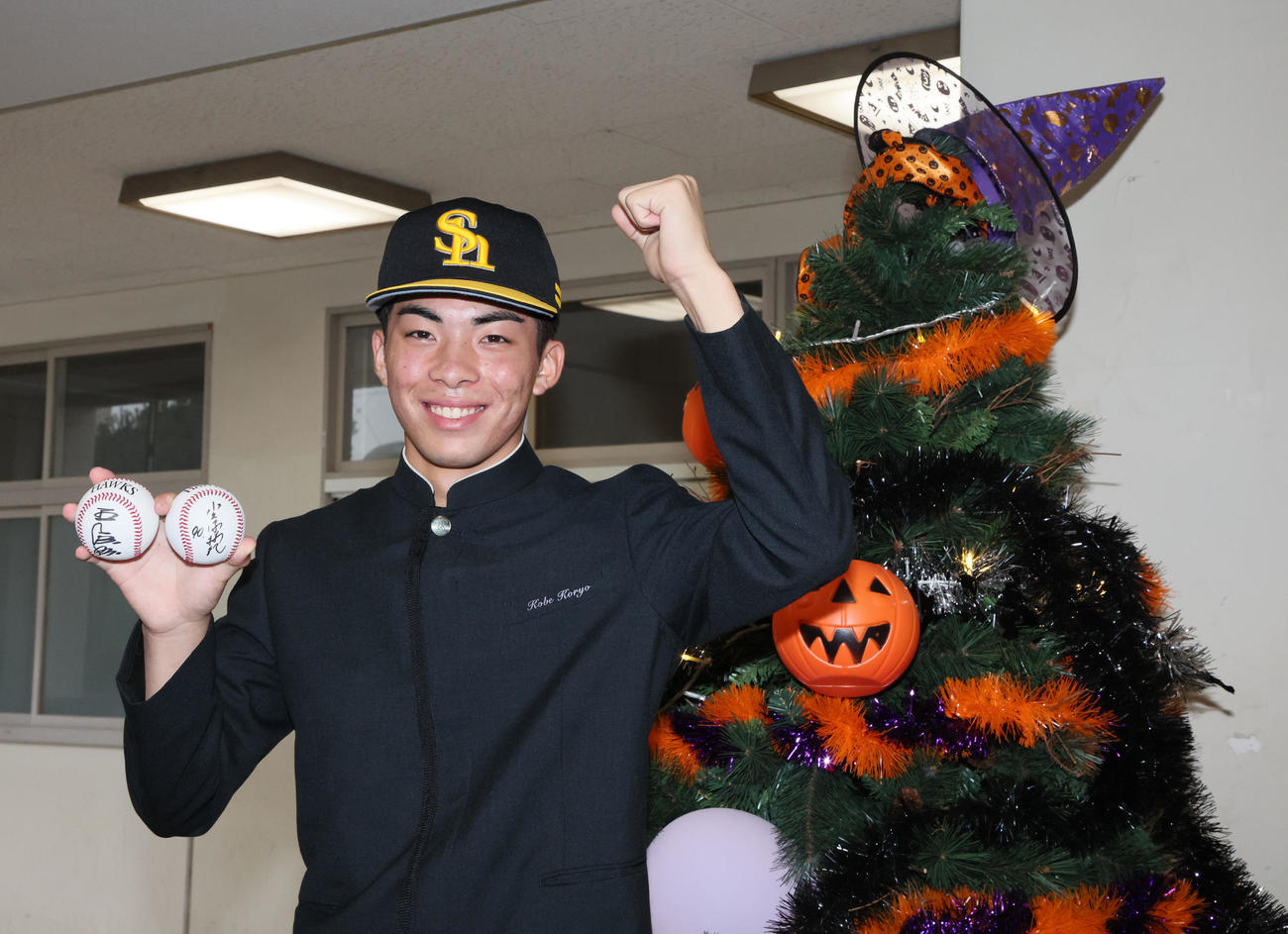 ソフトバンクからドラフト1位指名のあいさつを受けた村上は、校内に飾られたハロウィンツリーの隣で笑顔を見せる（撮影・加藤哉）
