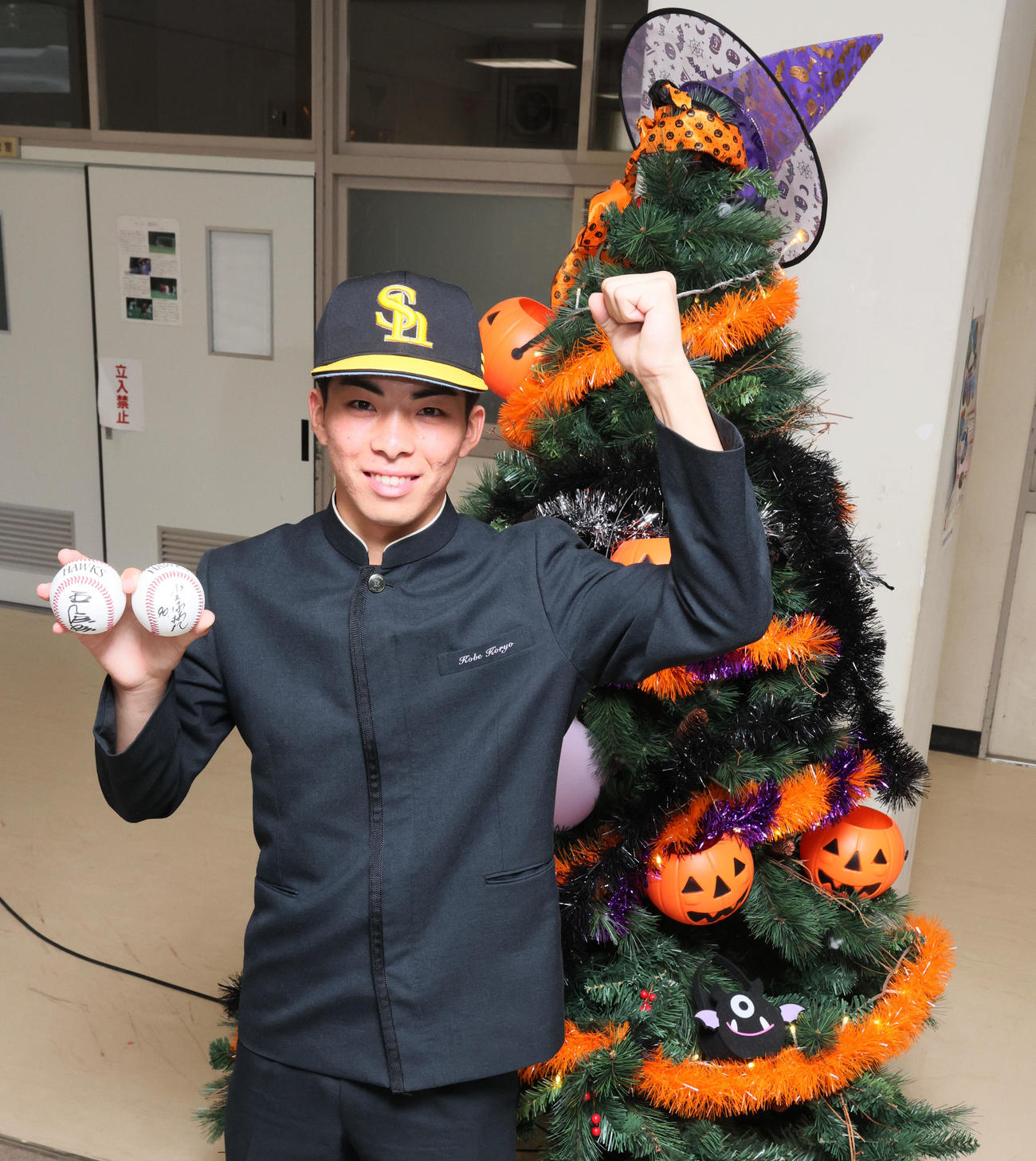ソフトバンクからドラフト1位指名のあいさつを受けた村上は、校内に飾られたハロウィンツリーの隣で笑顔を見せる（撮影・加藤哉）