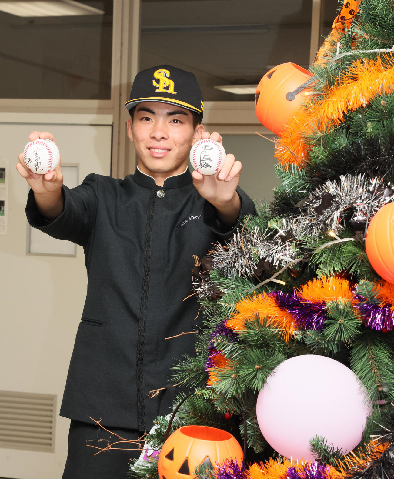 ソフトバンクからドラフト1位指名あいさつを受けた村上は校内にあるハロウィンツリーの隣で笑顔を見せる（撮影・加藤哉）