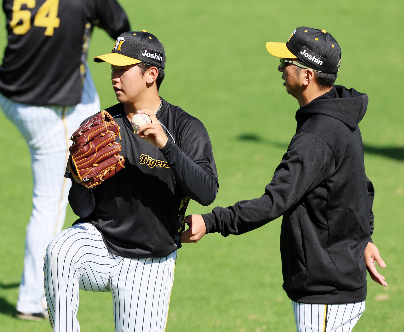 キャッチボールする門別（左）に手を伸ばしてアドバイスを送る藤川監督（撮影・加藤哉）
