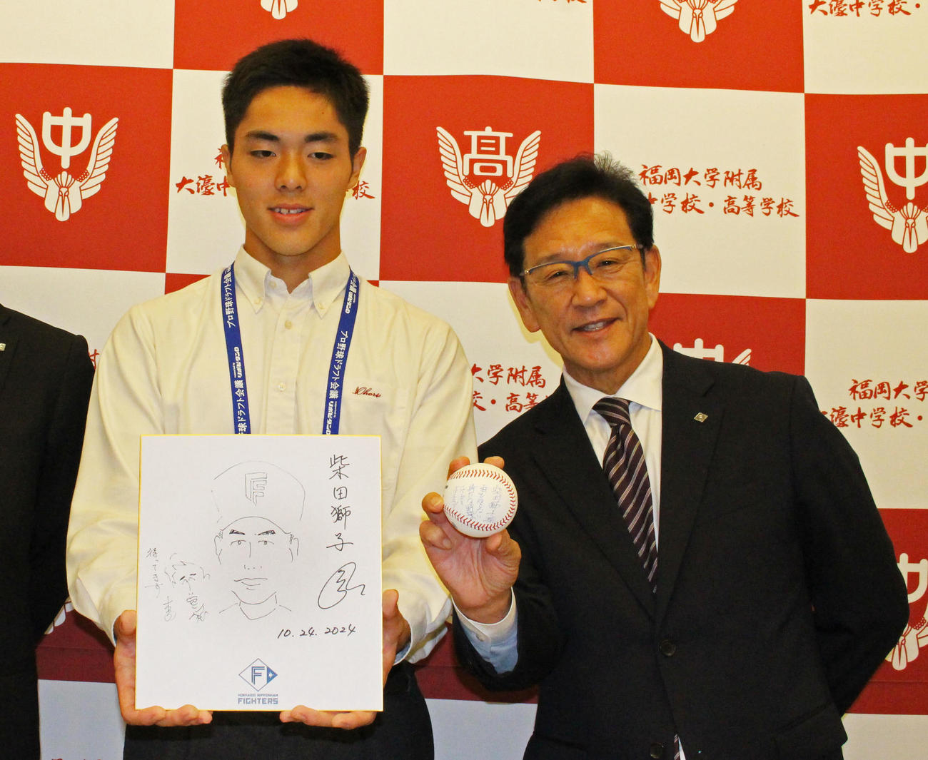 栗山CBO（右）と写真に収まる福岡大大濠・柴田。栗山CBOの持つボールには「誰も知らない新たな野球の一ページを作ろう」と書かれていた（撮影・菊川光一）