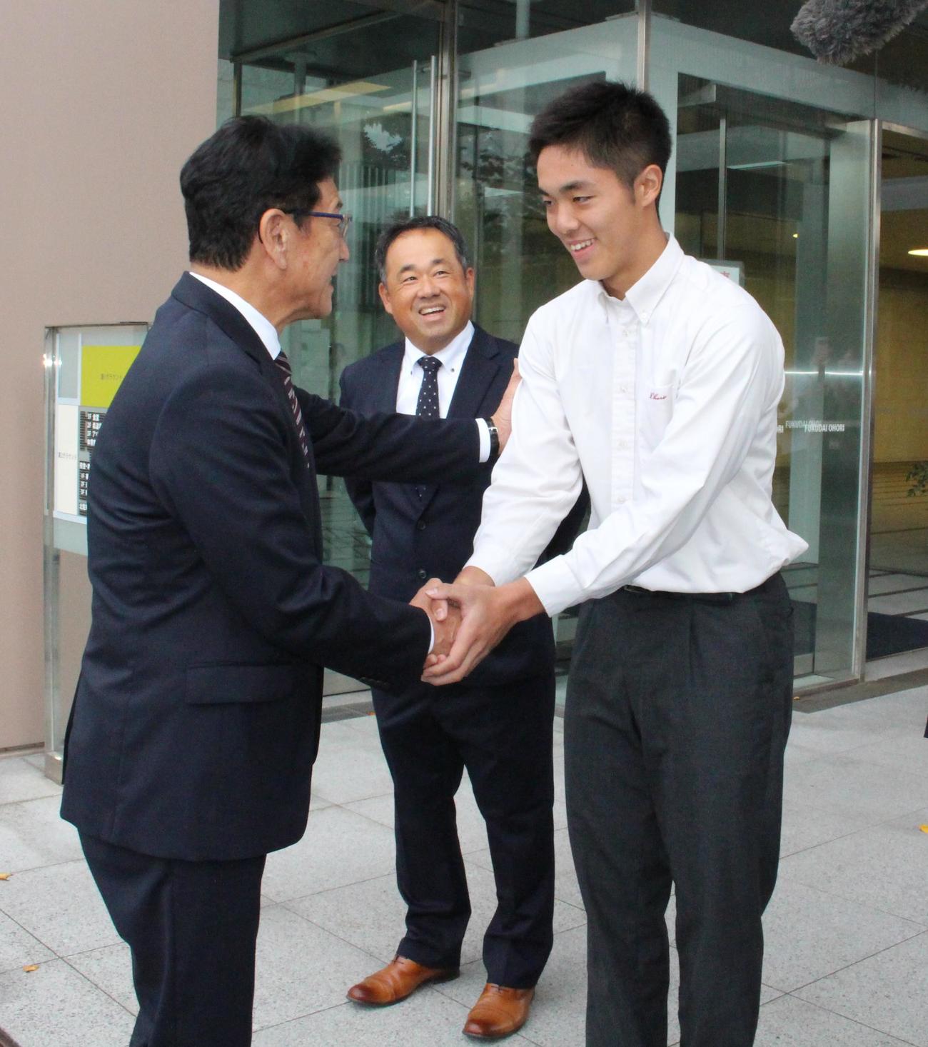 栗山CBO（左）を出迎えて握手する福岡大大濠・柴田（撮影・菊川光一）