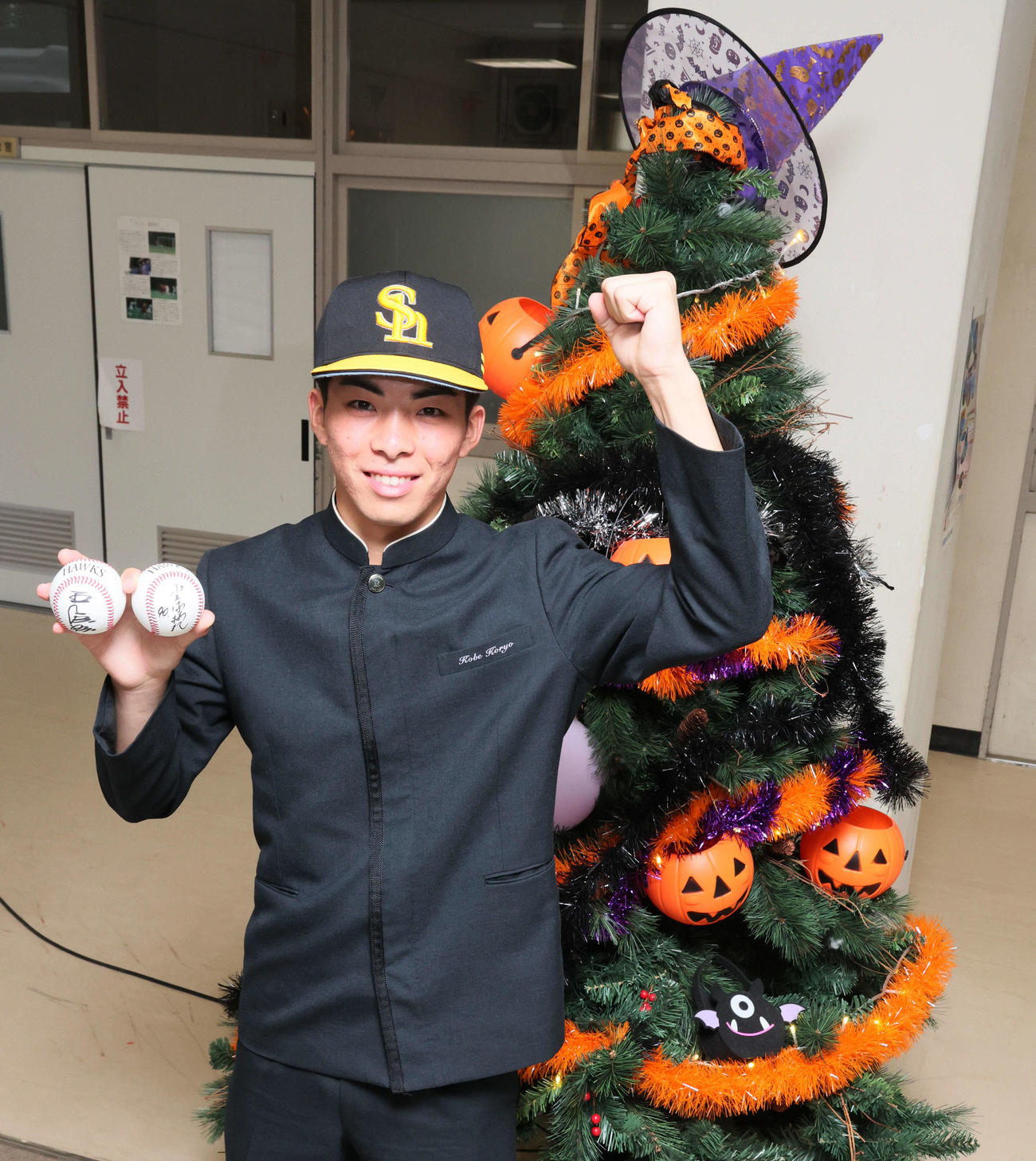 ソフトバンクからドラフト1位指名のあいさつを受けた村上は、校内に飾られたハロウィンツリーの隣で笑顔を見せる（撮影・加藤哉）