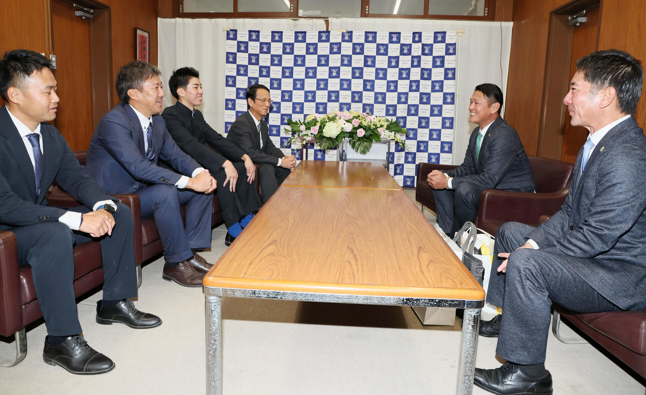ソフトバンクの永井本部長（右から2人目）、稲嶺スカウト（右端）のドラフト指名あいさつを受け笑顔を見せる村上（左から3人目）（撮影・加藤哉）